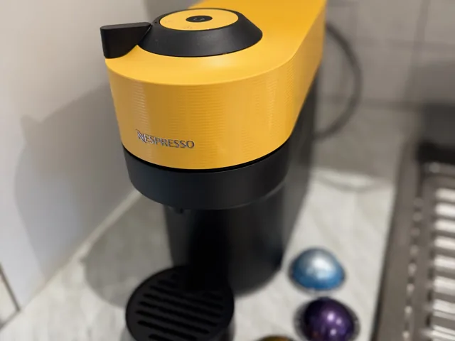 Žlutý kapslový kávovar Nespresso na kuchyňské lince