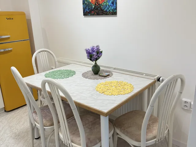 Bílý jídelní stůl se židlemi v kuchyni